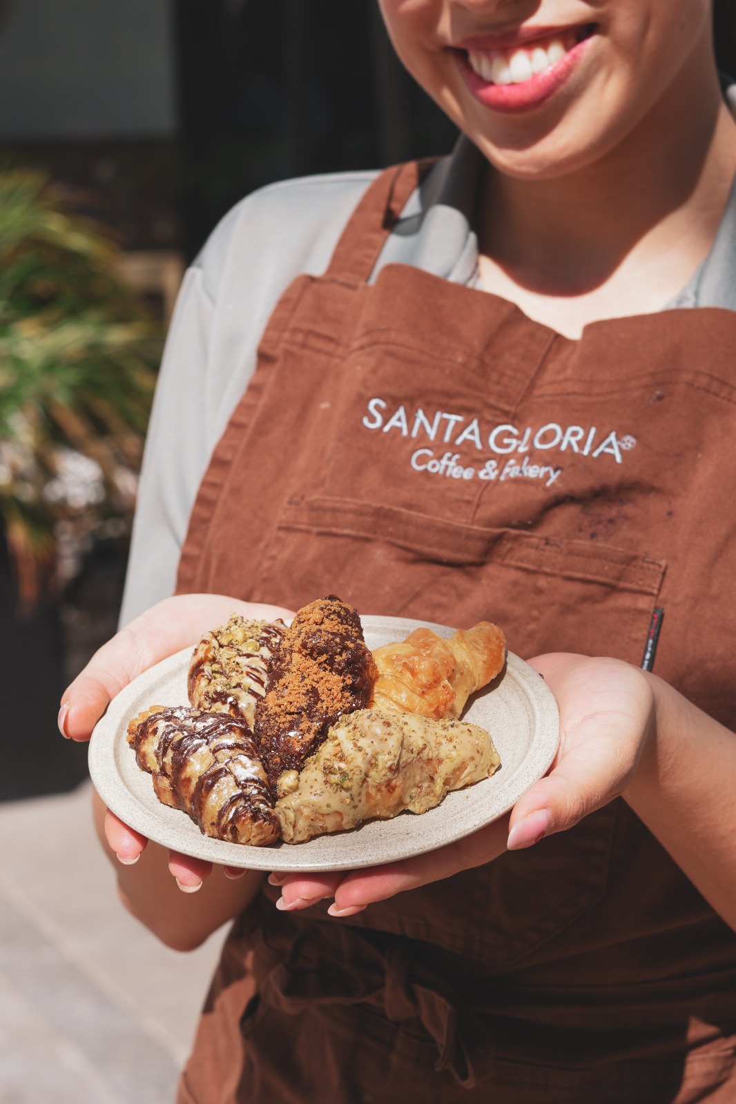 Colaboradora de Santa Gloria presentando una selección de croissants
